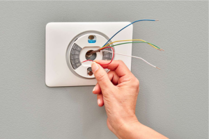 Technician setting up smart thermostat in Dubai