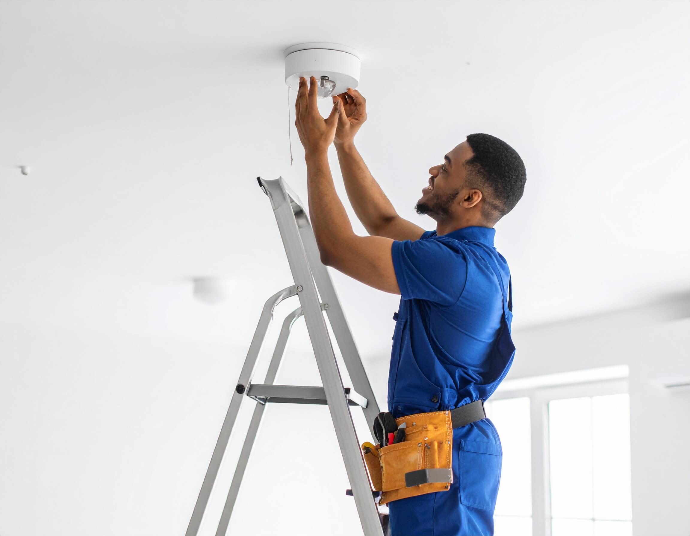Electrician replacing a ceiling light fixture